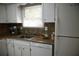 Well-lit kitchen with a stainless sink, white cabinets, and breakfast nook area at 3338 York Pl, Decatur, GA 30032