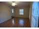 Spacious living room featuring hardwood floors, neutral paint, and ample natural light from the large windows at 3338 York Pl, Decatur, GA 30032