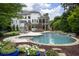 Beautiful backyard with a custom swimming pool, stone accents, covered patio, and lush greenery at 948 Saint Lyonn Cts, Marietta, GA 30068