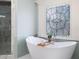 Freestanding bathtub with decorative window in spa-like bathroom with a tiled shower and luxury finishes at 948 Saint Lyonn Cts, Marietta, GA 30068