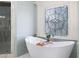 A freestanding bathtub sits beneath an ornately styled window, adjacent to a marble shower, giving a soothing ambiance at 948 Saint Lyonn Cts, Marietta, GA 30068