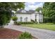 A stately home is pictured with a circular driveway and manicured lawn in a lush, green setting at 948 Saint Lyonn Cts, Marietta, GA 30068