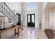 Welcoming foyer features a staircase, travertine flooring, and elegant black double-door entrance at 948 Saint Lyonn Cts, Marietta, GA 30068