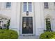 Elegant front entrance with black double doors, classic columns, and manicured landscaping at 948 Saint Lyonn Cts, Marietta, GA 30068