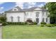 Elegant white home featuring a manicured lawn, mature trees, and a circular driveway at 948 Saint Lyonn Cts, Marietta, GA 30068