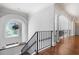 Hallway with hardwood floors, black railing, archways and a view of the trees outside at 948 Saint Lyonn Cts, Marietta, GA 30068