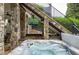 Outdoor hot tub and entertainment area with a TV and outdoor seating beneath an elevated staircase at 948 Saint Lyonn Cts, Marietta, GA 30068