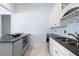 White kitchenette with dark counters, stainless steel appliances and tiled backsplash offering elegance at 948 Saint Lyonn Cts, Marietta, GA 30068