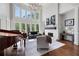 Bright living room featuring soaring ceilings, fireplace, piano, and large windows with scenic views at 948 Saint Lyonn Cts, Marietta, GA 30068
