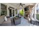 Relaxing outdoor patio with stone fireplace, ceiling fan, and comfortable seating area at 948 Saint Lyonn Cts, Marietta, GA 30068