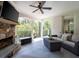 A covered patio with stone fireplace, comfortable sofa, and view of trees at 948 Saint Lyonn Cts, Marietta, GA 30068