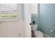 Blue powder room with white toilet, walls, and window at 948 Saint Lyonn Cts, Marietta, GA 30068