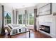 Cozy sitting room adjacent to main bedroom with fireplace, large windows, hardwood floors, and neutral tones at 948 Saint Lyonn Cts, Marietta, GA 30068
