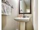 Classic half bathroom featuring a pedestal sink with a large mirror and a decorative towel rack at 2002 Orchard Terrace, Loganville, GA 30052