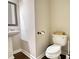 Cozy half bathroom with a toilet and floating sink, featuring dark brown wooden floors at 2002 Orchard Terrace, Loganville, GA 30052