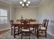 Traditional dining room with a wooden table, upholstered chairs, and elegant chandelier at 2002 Orchard Terrace, Loganville, GA 30052