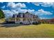 Charming two-story home with a spacious porch and well-manicured lawn under a blue sky at 2002 Orchard Terrace, Loganville, GA 30052