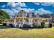 Charming two-story home with a spacious porch and well-manicured lawn under a blue sky at 2002 Orchard Terrace, Loganville, GA 30052