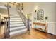 Elegant foyer featuring hardwood floors, a staircase, and a decorative mirror at 2002 Orchard Terrace, Loganville, GA 30052