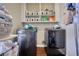 Laundry room with modern washer and dryer units, upper cabinets, and hardwood floors at 2002 Orchard Terrace, Loganville, GA 30052