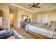 This main bedroom boasts a large wooden bedframe and a trey ceiling with fan at 2002 Orchard Terrace, Loganville, GA 30052