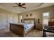 This main bedroom features a trey ceiling, fan, and warm neutral colors at 2002 Orchard Terrace, Loganville, GA 30052