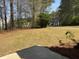 View of a spacious backyard featuring lawn and mature trees at 4580 Darrowby Dr, Powder Springs, GA 30127