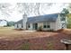 A view of the spacious backyard with mature trees, pine straw, and patio at 4580 Darrowby Dr, Powder Springs, GA 30127