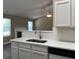 Bright kitchen with white cabinets, stainless steel sink and view of the living room at 4580 Darrowby Dr, Powder Springs, GA 30127