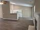Living room features neutral paint, wood-look flooring, vaulted ceiling, and breakfast bar to kitchen at 4580 Darrowby Dr, Powder Springs, GA 30127