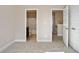 This bedroom has neutral carpeting and a view into an adjacent bathroom and hallway at 3935 Cordano Ln, Lawrenceville, GA 30044