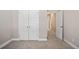 A large bedroom with neutral carpets, double doors, and a glimpse of the hallway at 3935 Cordano Ln, Lawrenceville, GA 30044