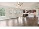 Open-concept living area with hardwood floors, large windows, and a modern kitchen at 3935 Cordano Ln, Lawrenceville, GA 30044