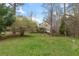 Large backyard featuring a lawn, trees, and a wooden fence surrounding the property at 7810 Rose Ct, Cumming, GA 30040