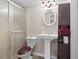 Cozy bathroom features a glass shower, white pedestal sink, octagonal mirror, and linen cabinet with towels at 7810 Rose Ct, Cumming, GA 30040