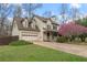 Charming two-story home with a manicured lawn, flowering tree, and an attached two-car garage at 7810 Rose Ct, Cumming, GA 30040