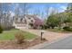 View of home's front lawn, blooming tree, two-car garage, driveway, and mailbox at 7810 Rose Ct, Cumming, GA 30040