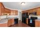 Functional kitchen with wood cabinets, black appliances, and ample counter space at 7810 Rose Ct, Cumming, GA 30040