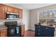 Kitchen featuring stainless steel microwave, black oven, and an island with a view to the deck at 7810 Rose Ct, Cumming, GA 30040
