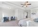 Primary bedroom featuring tray ceiling, carpet floors, and light-filled space with view into another bedroom at 3906 Lockaby Way, Lawrenceville, GA 30044