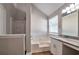 A bathtub and shower combination next to the vanity and mirror, with natural light from the window at 4410 Millenium View Ct, Snellville, GA 30039