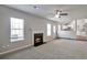 Inviting living room featuring fireplace, neutral carpet, ceiling fan, and open to kitchen at 4410 Millenium View Ct, Snellville, GA 30039