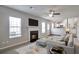Inviting living room featuring fireplace, neutral carpet, ceiling fan, and open to kitchen at 4410 Millenium View Ct, Snellville, GA 30039