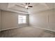 Spacious main bedroom with tray ceiling, neutral walls, carpet, and natural light at 4410 Millenium View Ct, Snellville, GA 30039