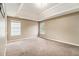 Bonus room with tray ceiling, neutral paint, and neutral carpet provides a versatile space to customize at 5080 Galleon Xing, Decatur, GA 30035