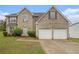 Traditional two-story brick home featuring an attached two-car garage, arched window, and manicured landscaping at 5080 Galleon Xing, Decatur, GA 30035