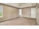 Light filled main bedroom features tray ceiling, neutral carpet, and doorway to ensuite bath at 5080 Galleon Xing, Decatur, GA 30035