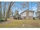View of the brick and siding house, deck, and yard surrounded by trees at 5140 Cowart Ct, Powder Springs, GA 30127