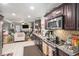 Functional kitchen layout featuring stainless appliances, mosaic tile backsplash, and a view of the living area at 5140 Cowart Ct, Powder Springs, GA 30127