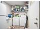 Functional laundry room with white appliances, shelving for storage, and convenient access to the exterior at 5140 Cowart Ct, Powder Springs, GA 30127